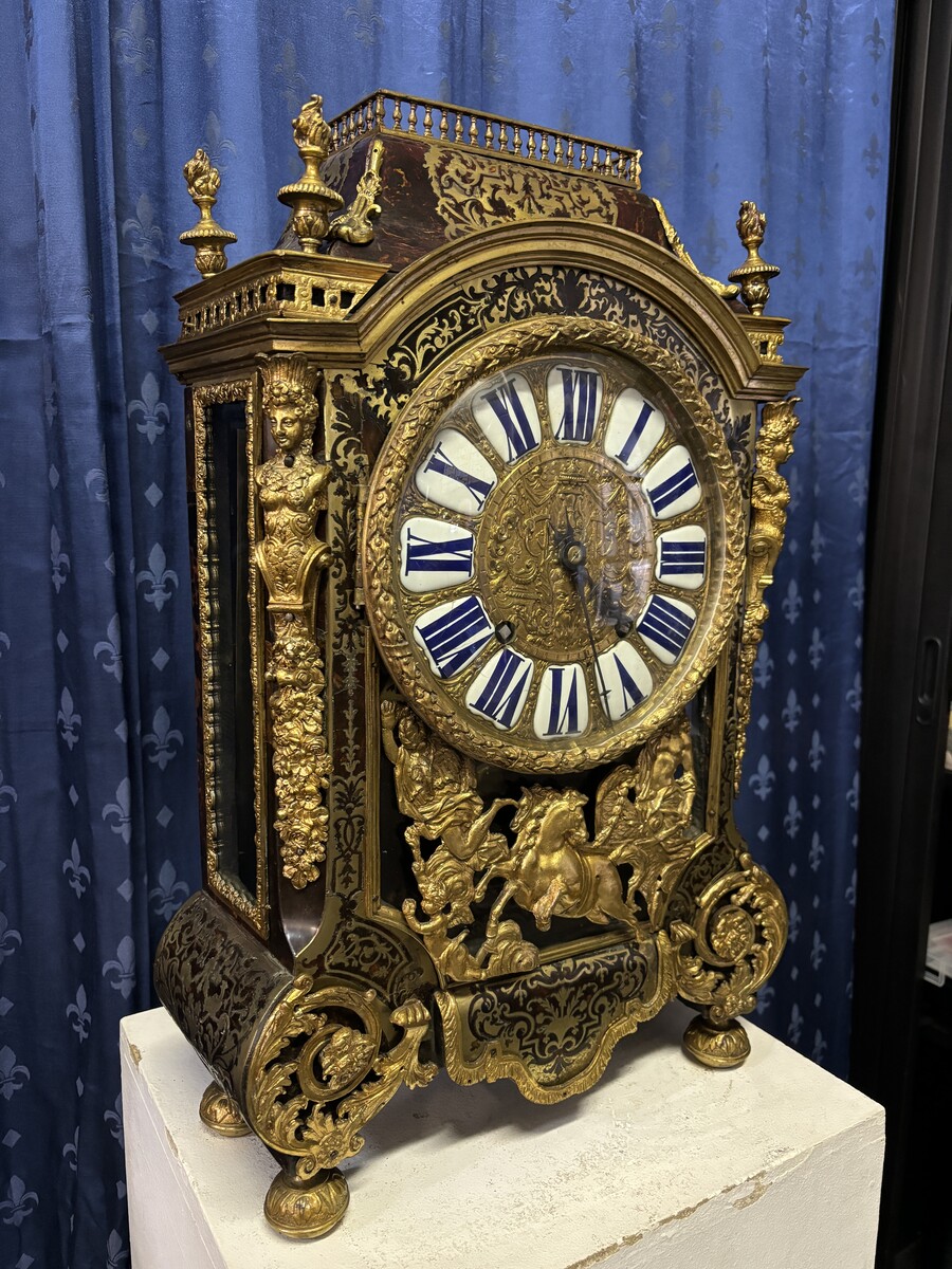 A large brass inlaid cartel on a tortoiseshell background, 18th century, Régence period. Rectangular cartel ending in scrolls decorated with gilt bronze on the front and a tripod in the centre. Gilt bronze dial with enamelled cartouches 