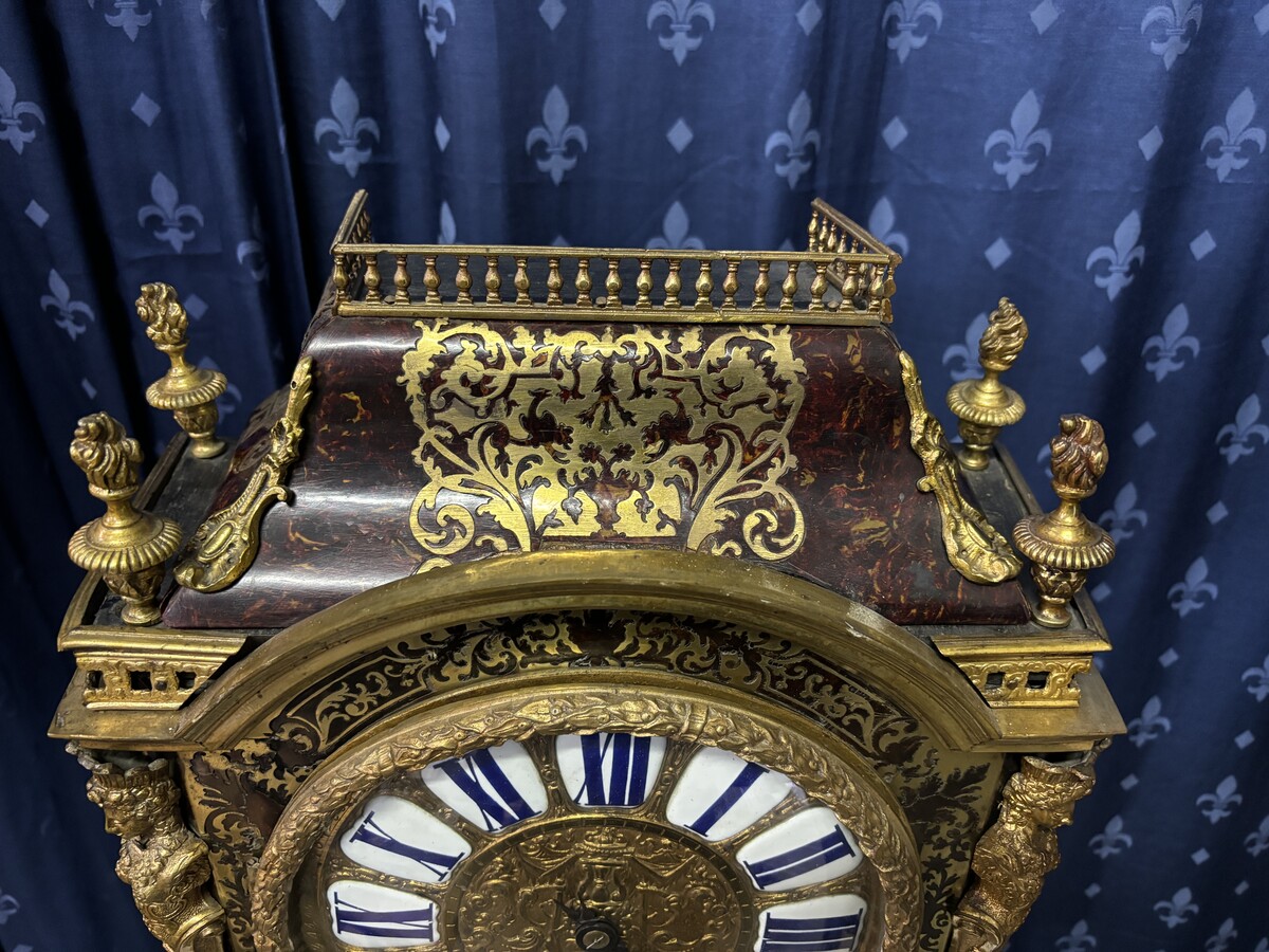 A large brass inlaid cartel on a tortoiseshell background, 18th century, Régence period. Rectangular cartel ending in scrolls decorated with gilt bronze on the front and a tripod in the centre. Gilt bronze dial with enamelled cartouches 