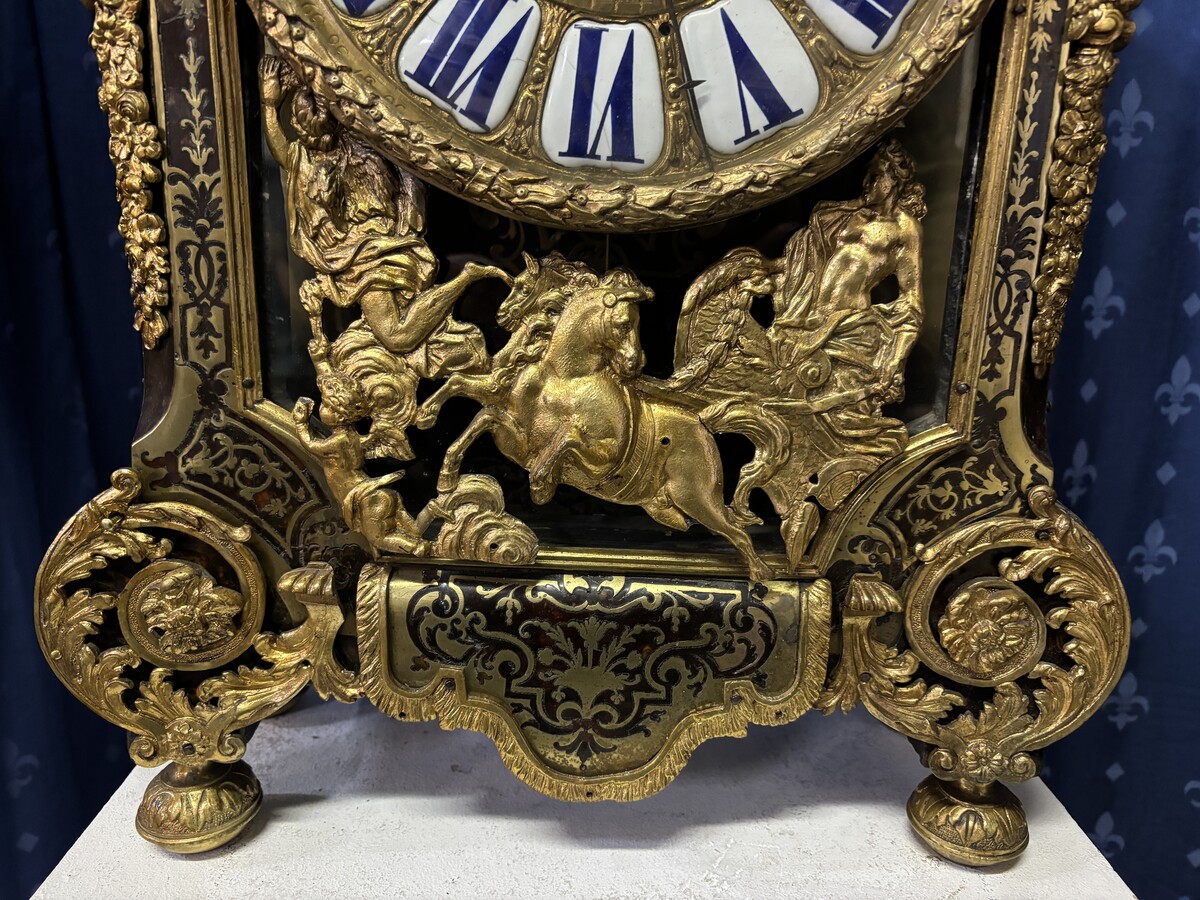 A large brass inlaid cartel on a tortoiseshell background, 18th century, Régence period. Rectangular cartel ending in scrolls decorated with gilt bronze on the front and a tripod in the centre. Gilt bronze dial with enamelled cartouches 