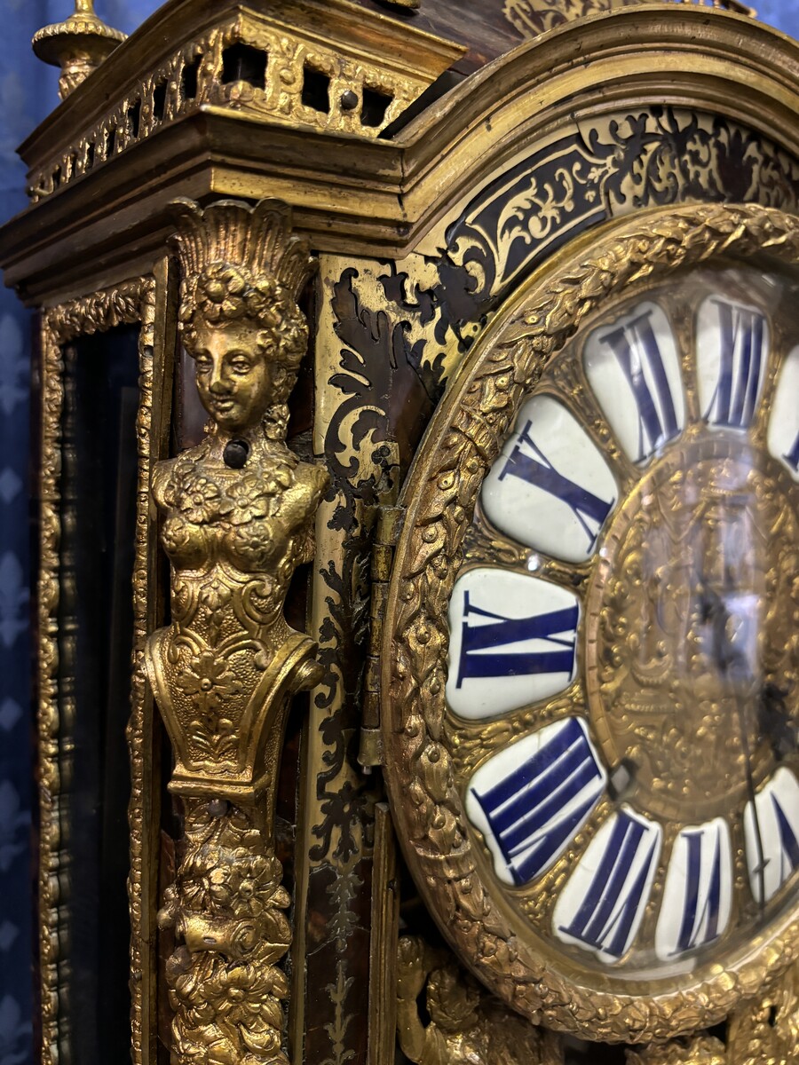 A large brass inlaid cartel on a tortoiseshell background, 18th century, Régence period. Rectangular cartel ending in scrolls decorated with gilt bronze on the front and a tripod in the centre. Gilt bronze dial with enamelled cartouches 