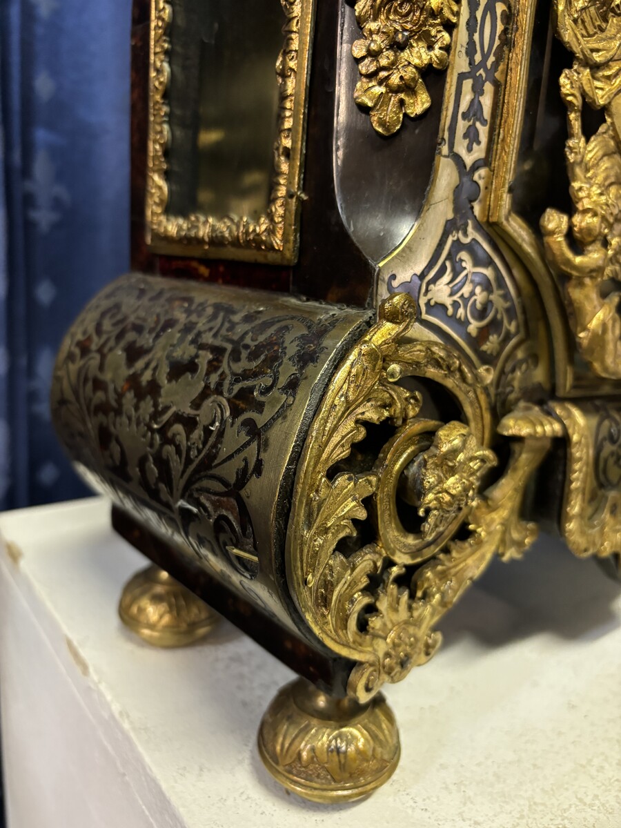 A large brass inlaid cartel on a tortoiseshell background, 18th century, Régence period. Rectangular cartel ending in scrolls decorated with gilt bronze on the front and a tripod in the centre. Gilt bronze dial with enamelled cartouches 