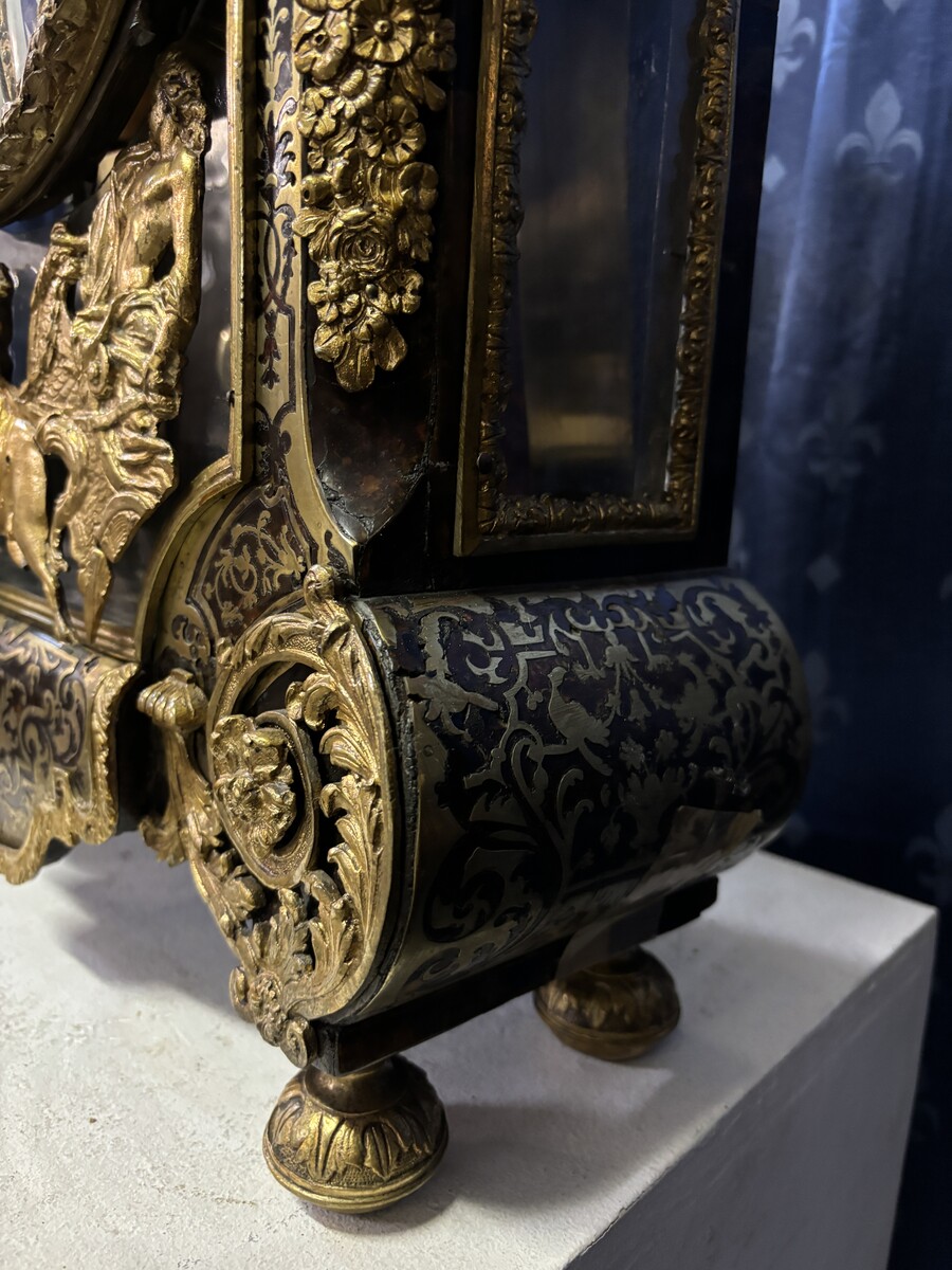 A large brass inlaid cartel on a tortoiseshell background, 18th century, Régence period. Rectangular cartel ending in scrolls decorated with gilt bronze on the front and a tripod in the centre. Gilt bronze dial with enamelled cartouches 