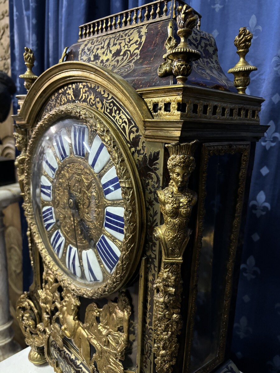 A large brass inlaid cartel on a tortoiseshell background, 18th century, Régence period. Rectangular cartel ending in scrolls decorated with gilt bronze on the front and a tripod in the centre. Gilt bronze dial with enamelled cartouches 