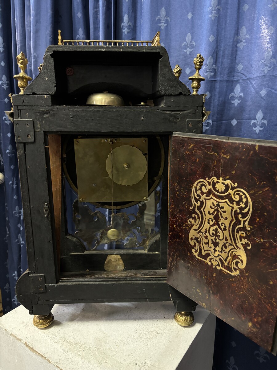 A large brass inlaid cartel on a tortoiseshell background, 18th century, Régence period. Rectangular cartel ending in scrolls decorated with gilt bronze on the front and a tripod in the centre. Gilt bronze dial with enamelled cartouches 