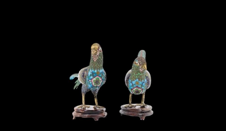 A pair of pheasants in finely crafted emaille cloisonné. 20th century. Decorative pair of sculptures standing on a wooden base Dimensions : Rooster: 19 x 37 cm. (incl. base)  Hen: 18 x 38 cm. (incl. base)  In good condition with a small peeling on the hen