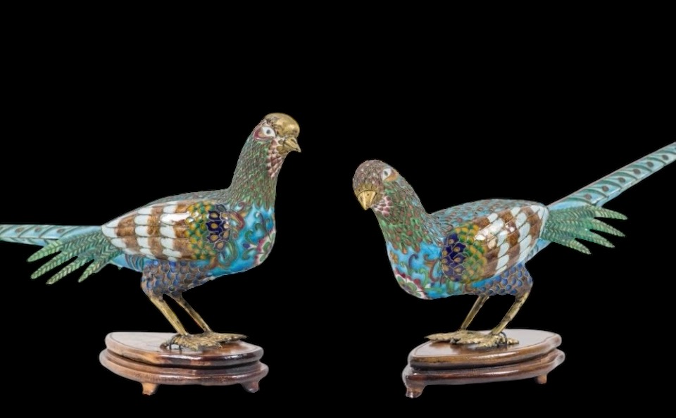 A pair of pheasants in finely crafted emaille cloisonné. 20th century. Decorative pair of sculptures standing on a wooden base Dimensions : Rooster: 19 x 37 cm. (incl. base)  Hen: 18 x 38 cm. (incl. base)  In good condition with a small peeling on the hen