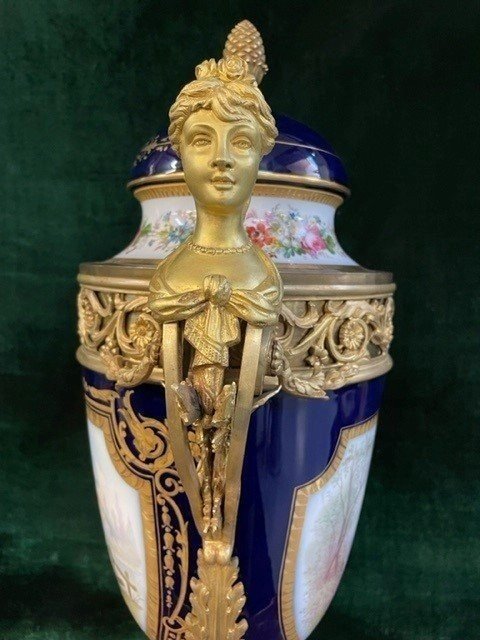 A Very Large Napoleon III Period Vase In Sevres Porcelain Decorated With A Gallant Scene On One Side And A Landscape On The Other Side, Gilded With Gold, Floral Motif And Oven Blue Background. Chased Bronze And Gilt Bronze Mount