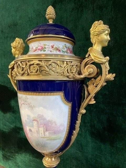 A Very Large Napoleon III Period Vase In Sevres Porcelain Decorated With A Gallant Scene On One Side And A Landscape On The Other Side, Gilded With Gold, Floral Motif And Oven Blue Background. Chased Bronze And Gilt Bronze Mount