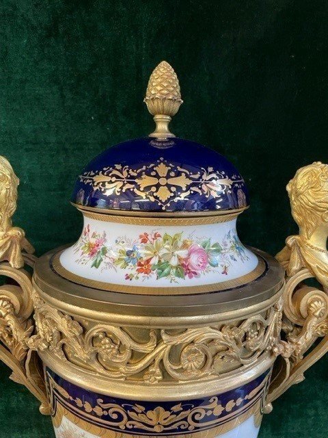 A Very Large Napoleon III Period Vase In Sevres Porcelain Decorated With A Gallant Scene On One Side And A Landscape On The Other Side, Gilded With Gold, Floral Motif And Oven Blue Background. Chased Bronze And Gilt Bronze Mount