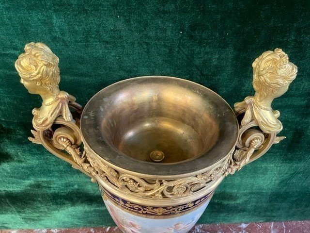 A Very Large Napoleon III Period Vase In Sevres Porcelain Decorated With A Gallant Scene On One Side And A Landscape On The Other Side, Gilded With Gold, Floral Motif And Oven Blue Background. Chased Bronze And Gilt Bronze Mount