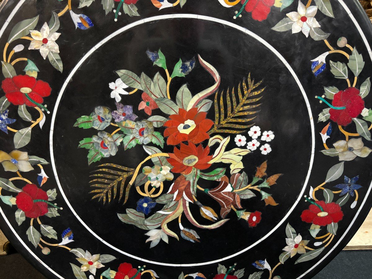 Beautiful guéridon with inlaid marble top on unusual wooden base. Large round table top in Italian pietra dura with flowers and beautiful colours on a beautiful ‘winged mythological beasts’ base 