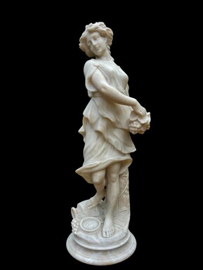 Beautiful sculpture of a young lady in alabaster from the late 19th century. Beautiful sculpture of a young lady with vines in her hair and hands. In good condition with minor damage to the round plinth at the back.