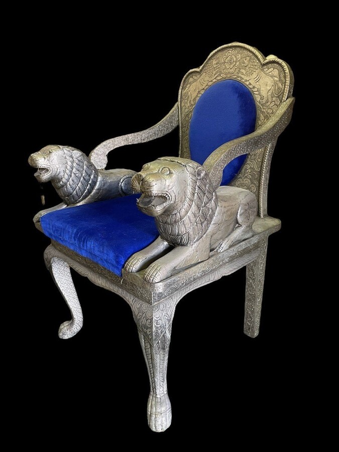 Decorative Orientalist armchair covered with tooled metal. The armchair is decorated with lions serving as armrests and is completely covered with a thin layer of silver metal decorated with flowers and ornaments and colourful fabric