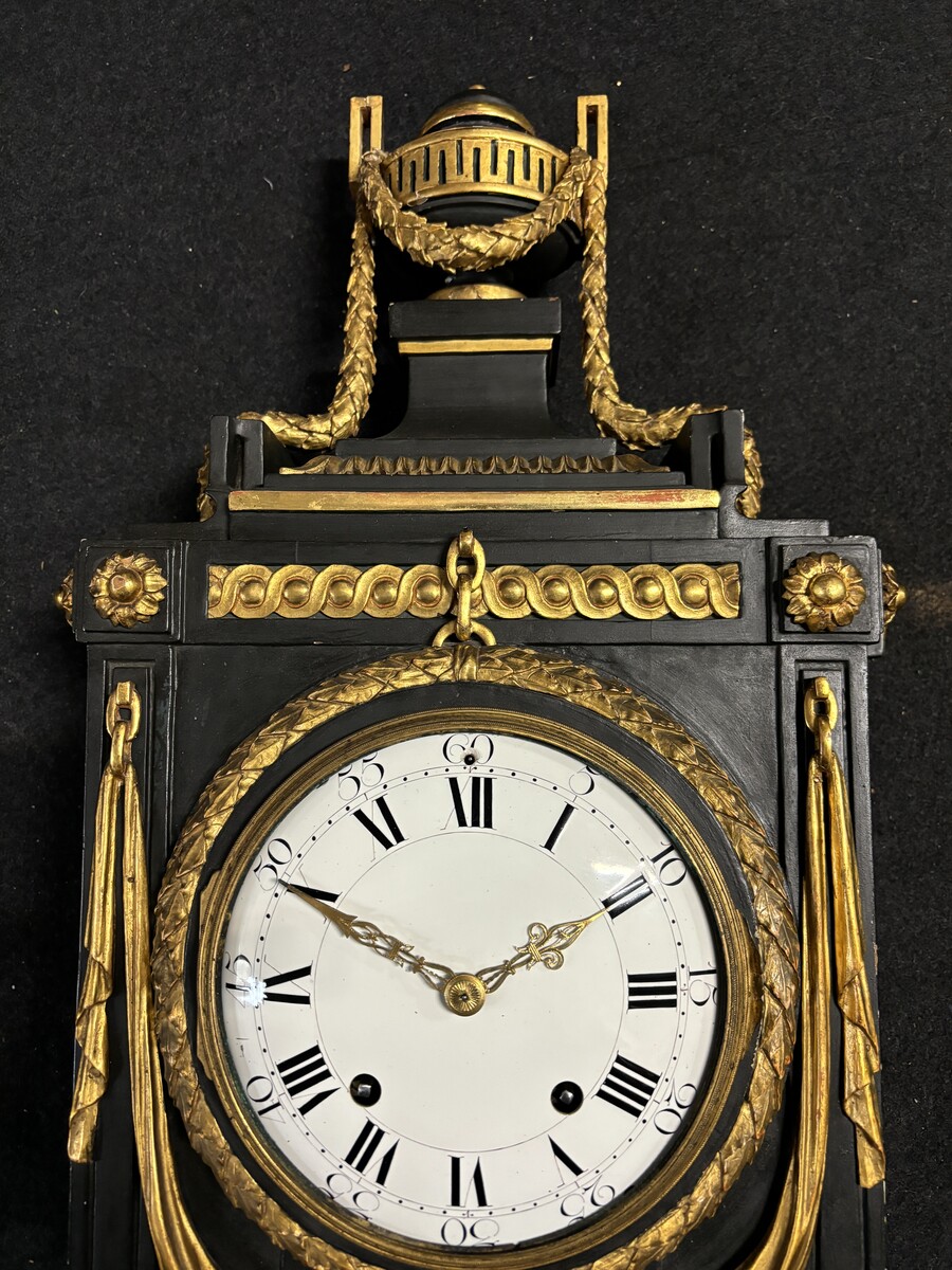 Large 18th century Louis XVI style wooden wall clock ( 78 cm ). Decorative cartel in black and gilded wood with the following dimensions: Height : 78 cm Width : 35 cm Depth : 18 cm. 18th century cartel in good condition with original clock.