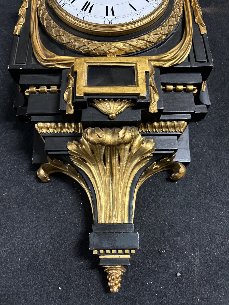 Large 18th century Louis XVI style wooden wall clock ( 78 cm ). Decorative cartel in black and gilded wood with the following dimensions: Height : 78 cm Width : 35 cm Depth : 18 cm. 18th century cartel in good condition with original clock.