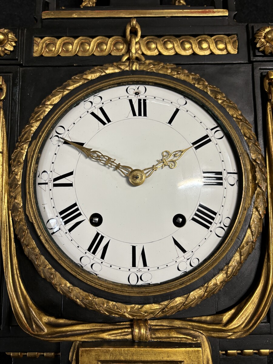 Large 18th century Louis XVI style wooden wall clock ( 78 cm ). Decorative cartel in black and gilded wood with the following dimensions: Height : 78 cm Width : 35 cm Depth : 18 cm. 18th century cartel in good condition with original clock.