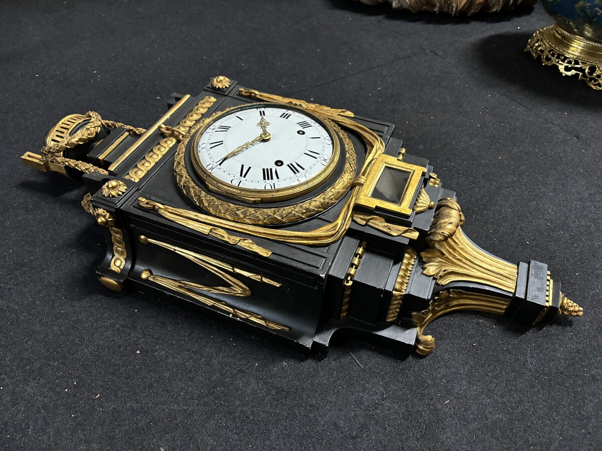 Large 18th century Louis XVI style wooden wall clock ( 78 cm ). Decorative cartel in black and gilded wood with the following dimensions: Height : 78 cm Width : 35 cm Depth : 18 cm. 18th century cartel in good condition with original clock.