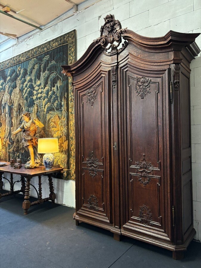 Large 2-door castle furniture in oak 18th century. Beautiful furniture with very finely sculpted doors and crest and inside fitted with shelves. Dimensions : Total height : 298 cm Width : 168 cm , 208 cm at the top Depth : 60 cm , 78 cm at the top