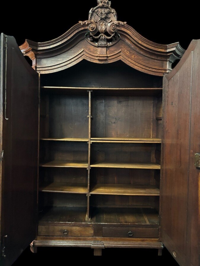 Large 2-door castle furniture in oak 18th century. Beautiful furniture with very finely sculpted doors and crest and inside fitted with shelves. Dimensions : Total height : 298 cm Width : 168 cm , 208 cm at the top Depth : 60 cm , 78 cm at the top