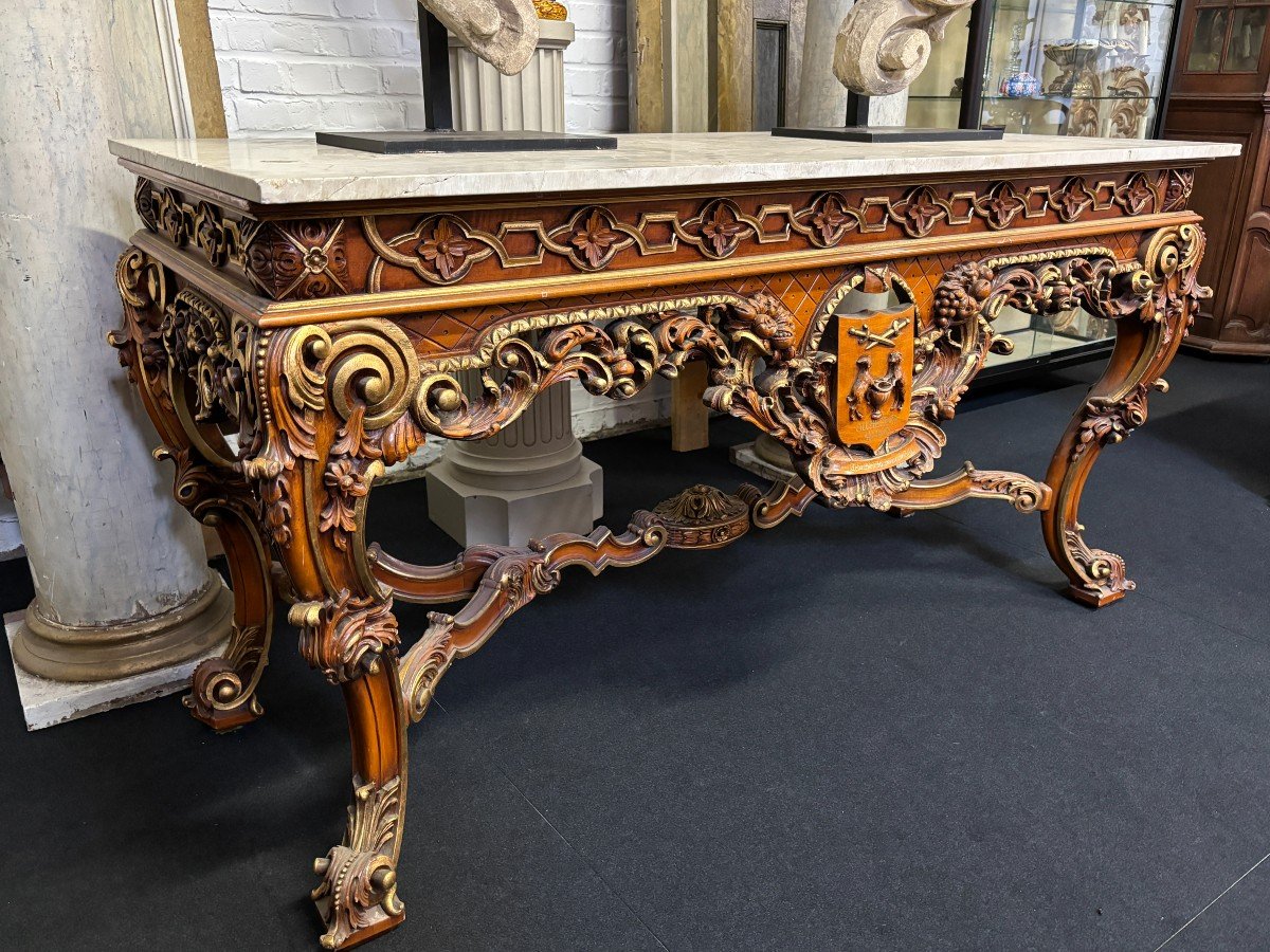 Large decorative console in carved wood 20th century. Beautiful console in wood with gilt accents and on top a top in travertine Dimensions : Width : 170 cm Height : 90 cm Depth : 71 cm In very good condition