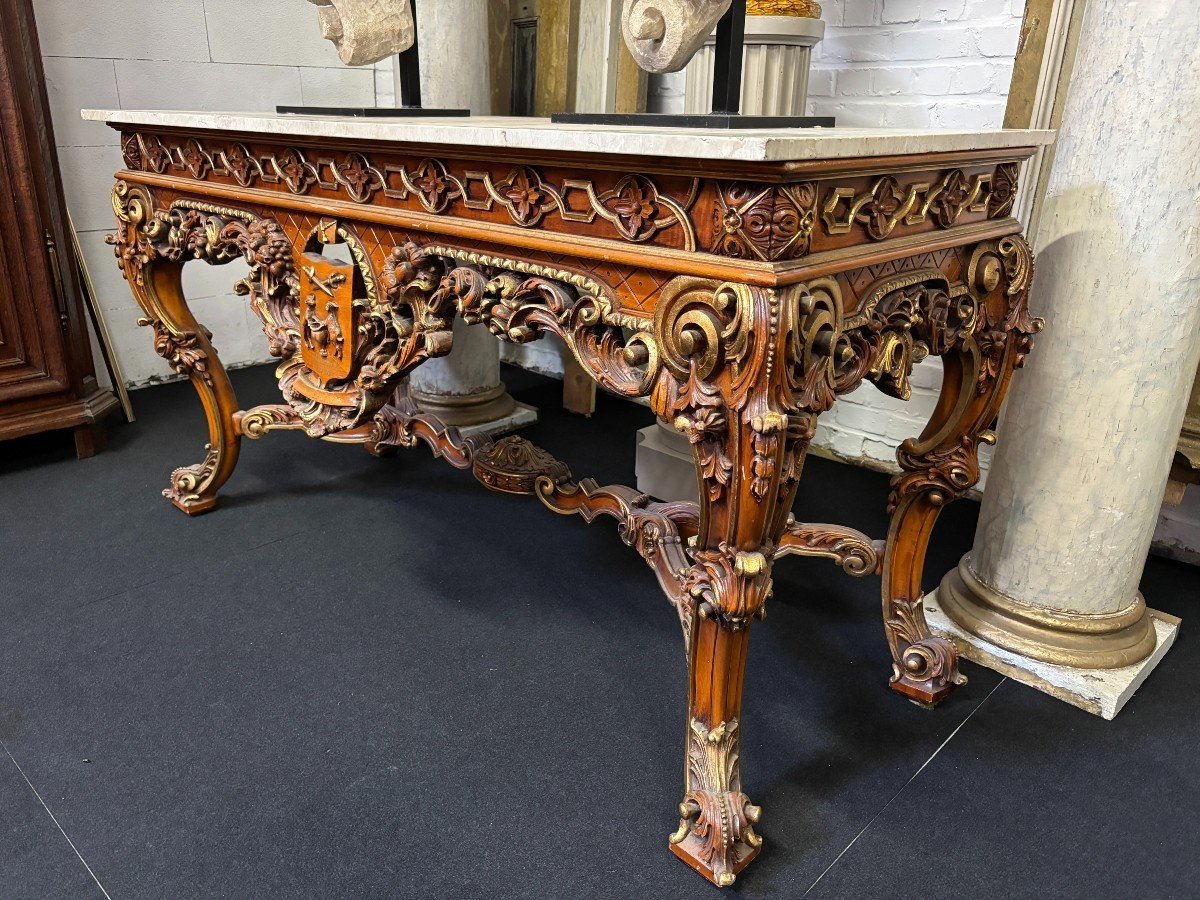 Large decorative console in carved wood 20th century. Beautiful console in wood with gilt accents and on top a top in travertine Dimensions : Width : 170 cm Height : 90 cm Depth : 71 cm In very good condition