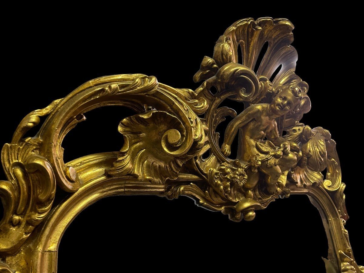 Large Louis XV style mirror with putti in gilded wood / stucco 19th century. Decorated with beautiful ornaments and at the top with a large putti. Dimensions: Height : 224 cm Width : 114 cm Decorative mirror in very good condition from around 1900