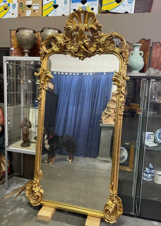 Large Louis XV style mirror with putti in gilded wood / stucco 19th century. Decorated with beautiful ornaments and at the top with a large putti. Dimensions: Height : 224 cm Width : 114 cm Decorative mirror in very good condition from around 1900