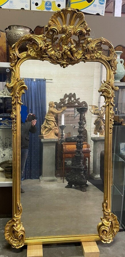 Large Louis XV style mirror with putti in gilded wood / stucco 19th century. Decorated with beautiful ornaments and at the top with a large putti. Dimensions: Height : 224 cm Width : 114 cm Decorative mirror in very good condition from around 1900