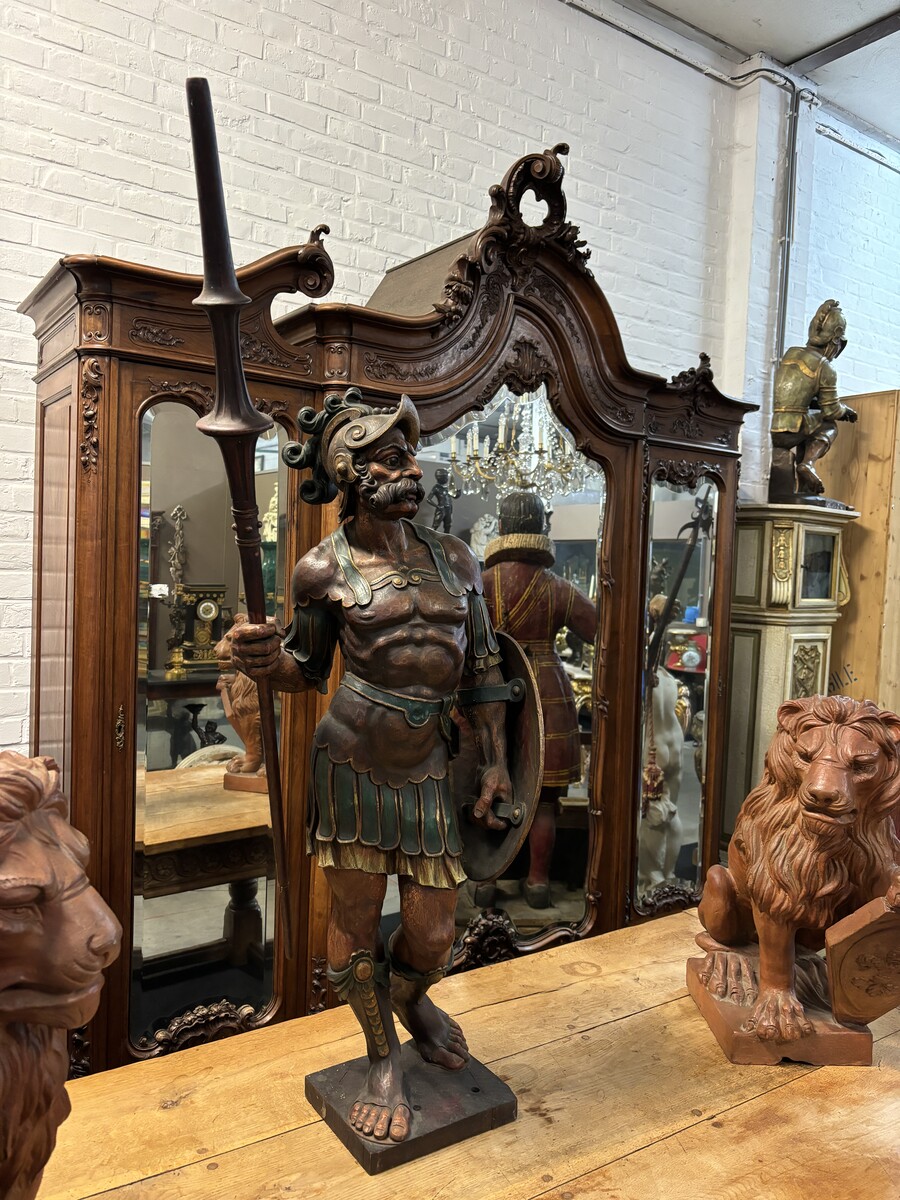 Large polychrome oak sculpture of a soldier/warrior late 19th century   Very decorative and detailed carving of a warrior with shield and spear. In very good condition. Dimensions : Height : 109 / 134 cm  Width : 49 cm Depth : 39 cm Foot : 26 x 21,5 cm Be