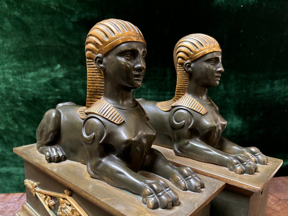 Pair of bronze empire-style sphinxes 19th century Decorative pair of patinated/gilt bronze sphinxes standing on pedestal Parts of chenets are present if desired ( see photo 12 ) Dimensions sphinx on plinth : Height : 30 cm Width : 28 cm Depth : 12 cm 