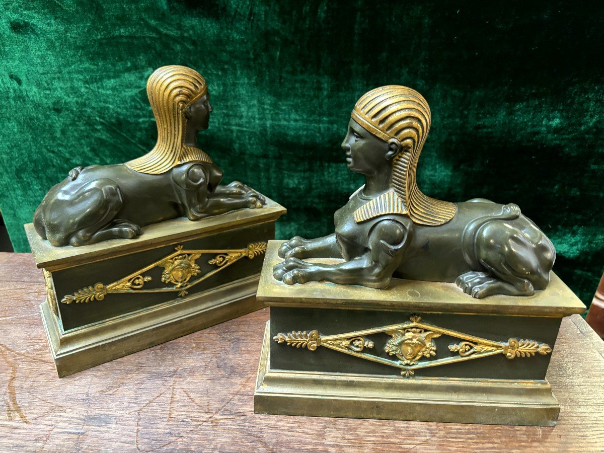 Pair of bronze empire-style sphinxes 19th century Decorative pair of patinated/gilt bronze sphinxes standing on pedestal Parts of chenets are present if desired ( see photo 12 ) Dimensions sphinx on plinth : Height : 30 cm Width : 28 cm Depth : 12 cm 