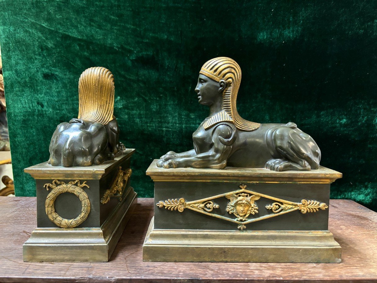 Pair of bronze empire-style sphinxes 19th century Decorative pair of patinated/gilt bronze sphinxes standing on pedestal Parts of chenets are present if desired ( see photo 12 ) Dimensions sphinx on plinth : Height : 30 cm Width : 28 cm Depth : 12 cm 