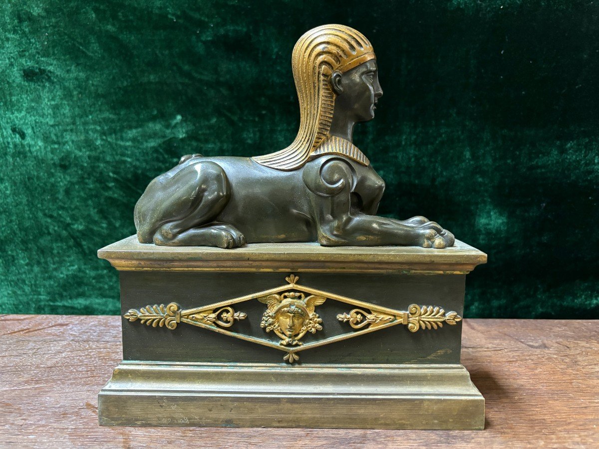 Pair of bronze empire-style sphinxes 19th century Decorative pair of patinated/gilt bronze sphinxes standing on pedestal Parts of chenets are present if desired ( see photo 12 ) Dimensions sphinx on plinth : Height : 30 cm Width : 28 cm Depth : 12 cm 