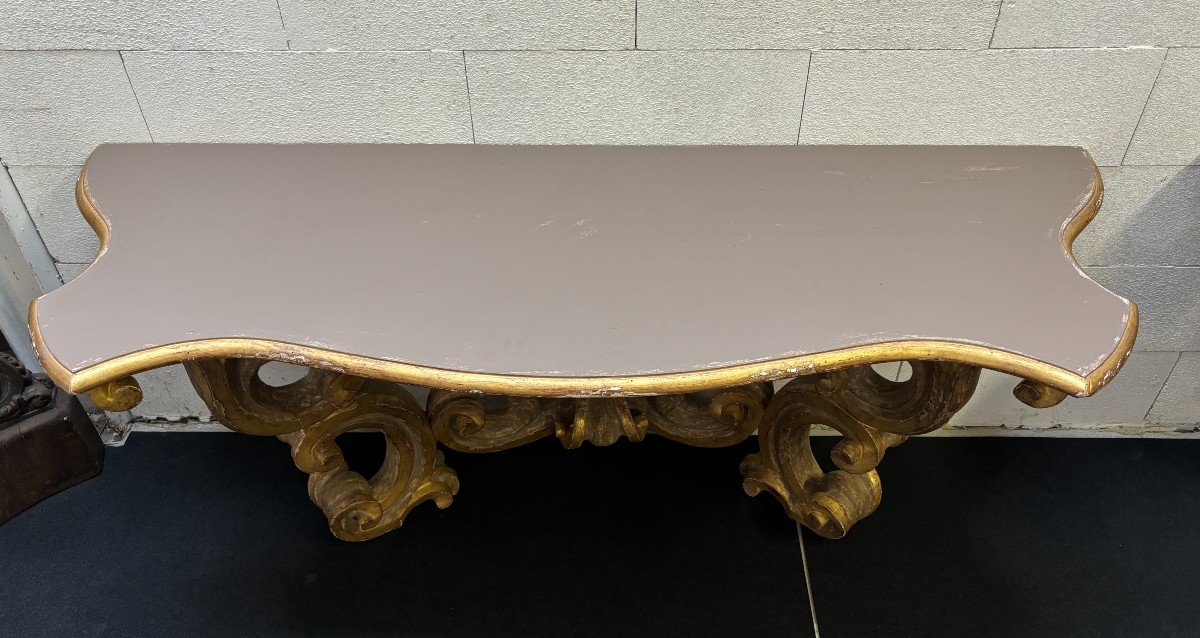 Pair of large consoles in gilt wood , Italian 18th century. Very decorative consoles decorated with large scrolls/ornaments in gilt wood with a painted top (tops in wood are recent , edge of table from the time). Dimensions : Width : 191 cm Height : 83,5