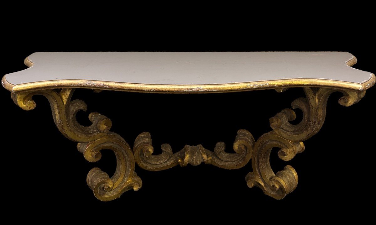 Pair of large consoles in gilt wood , Italian 18th century. Very decorative consoles decorated with large scrolls/ornaments in gilt wood with a painted top (tops in wood are recent , edge of table from the time). Dimensions : Width : 191 cm Height : 83,5