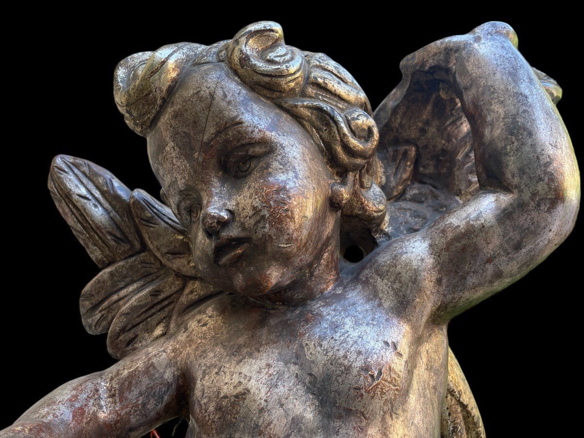 Pair of large silver/golden wood angels circa 1900. Decorative wooden angels in good condition. Dimensions: Height: 81 and 84 cm Width : 47 and 54 cm Depth : 24 and 25 cm Sculptures from Italy circa 1900