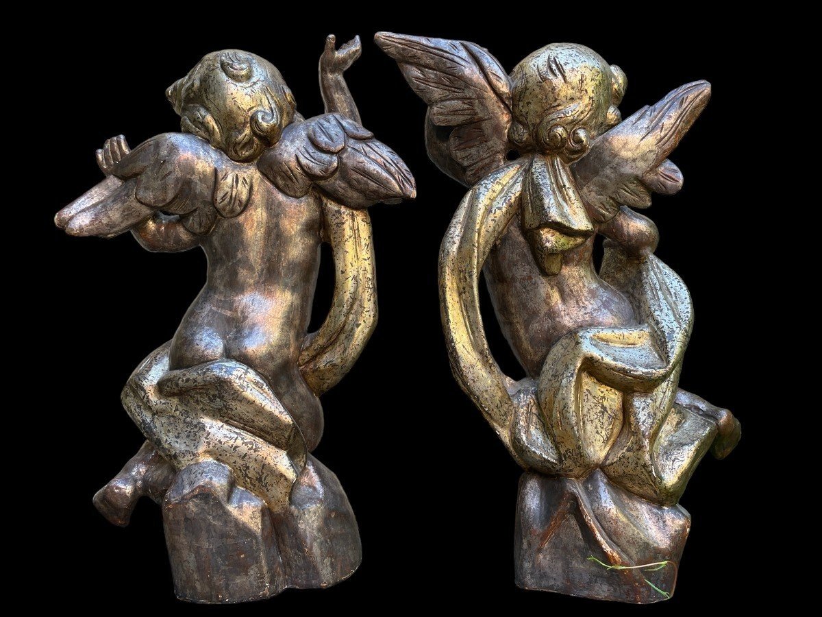 Pair of large silver/golden wood angels circa 1900. Decorative wooden angels in good condition. Dimensions: Height: 81 and 84 cm Width : 47 and 54 cm Depth : 24 and 25 cm Sculptures from Italy circa 1900