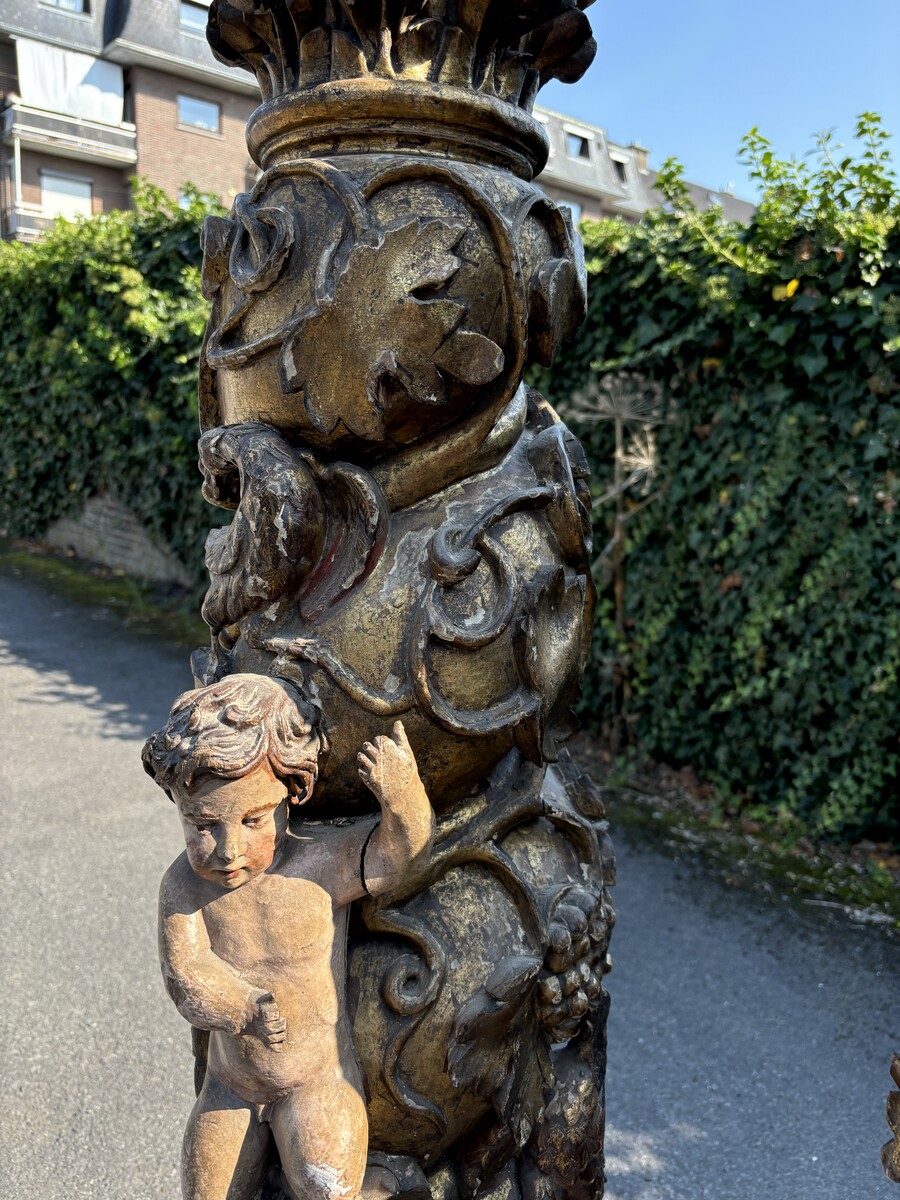 Pair of large turned columns with capitals 17th century. Very decorative polychrome oak columns from the Baroque period decorated with grapevines , birds, per column 2 putti and on top a corinthian capital The columns have some missing parts