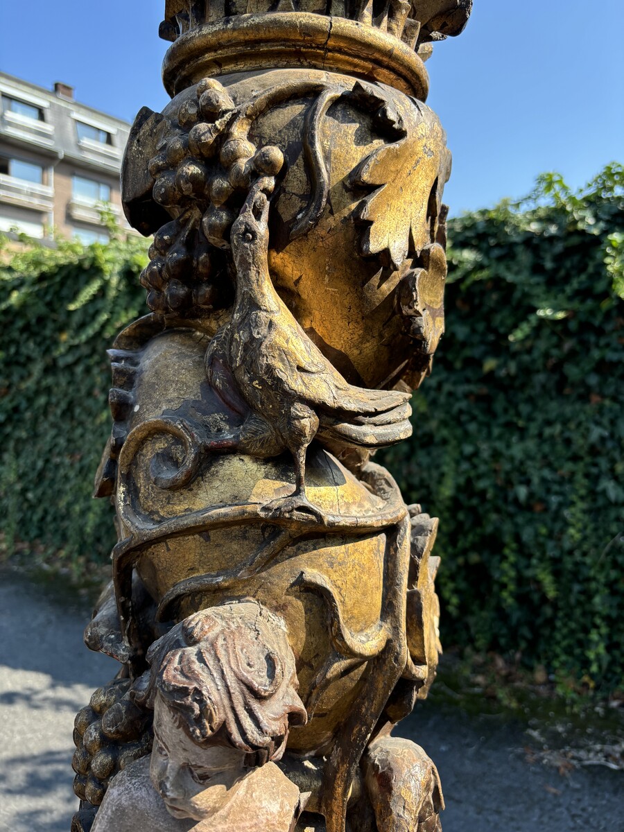 Pair of large turned columns with capitals 17th century. Very decorative polychrome oak columns from the Baroque period decorated with grapevines , birds, per column 2 putti and on top a corinthian capital The columns have some missing parts