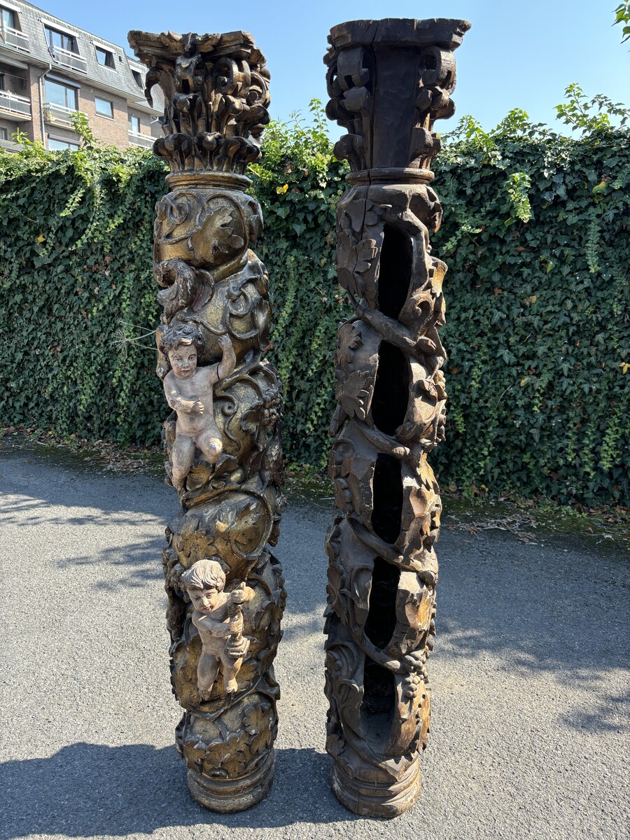 Pair of large turned columns with capitals 17th century. Very decorative polychrome oak columns from the Baroque period decorated with grapevines , birds, per column 2 putti and on top a corinthian capital The columns have some missing parts