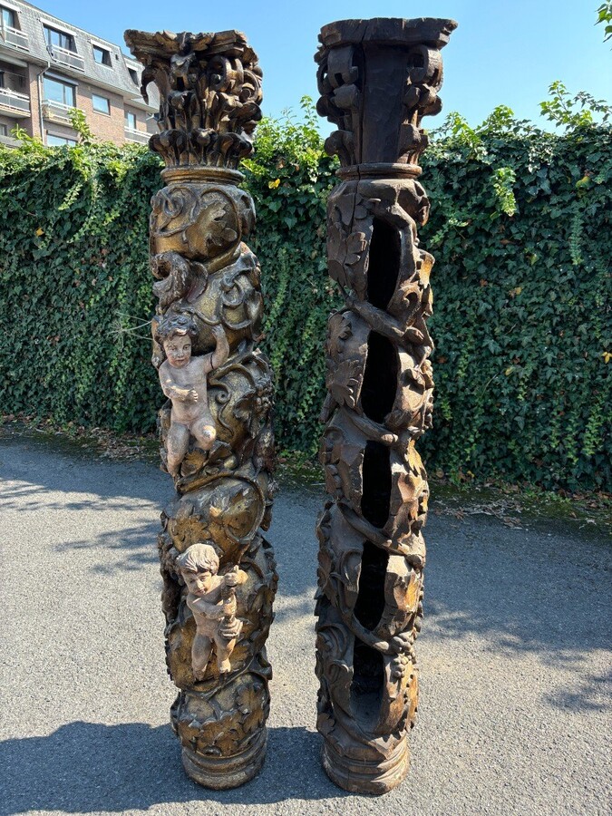  Pair of large turned columns with capitals 17th century. Very decorative polychrome oak columns from the Baroque period decorated with grapevines , birds, per column 2 putti and on top a corinthian capital The columns have some missing parts