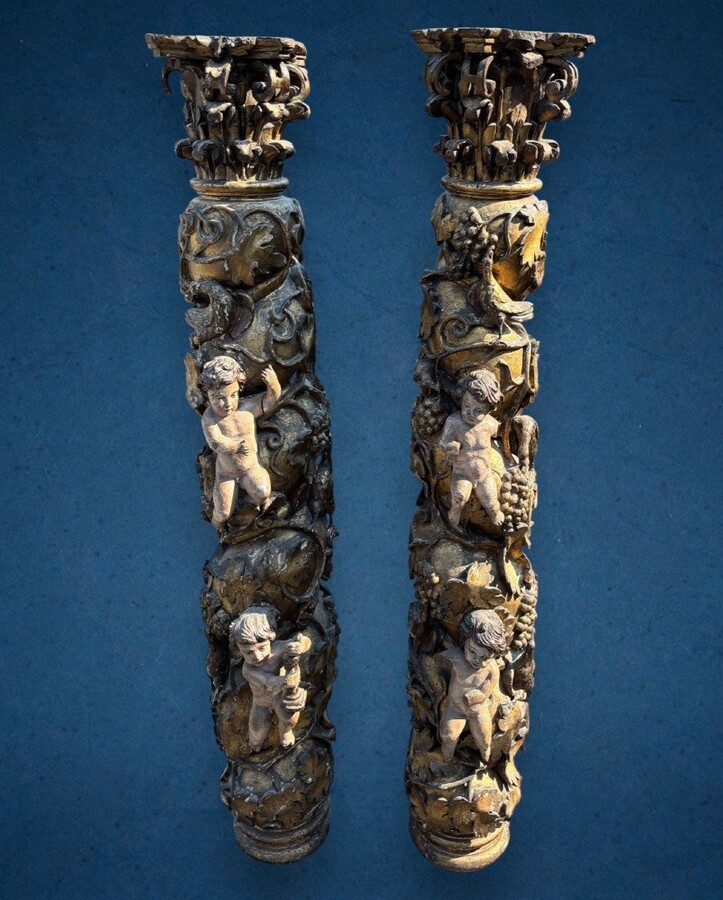  Pair of large turned columns with capitals 17th century. Very decorative polychrome oak columns from the Baroque period decorated with grapevines , birds, per column 2 putti and on top a corinthian capital The columns have some missing parts