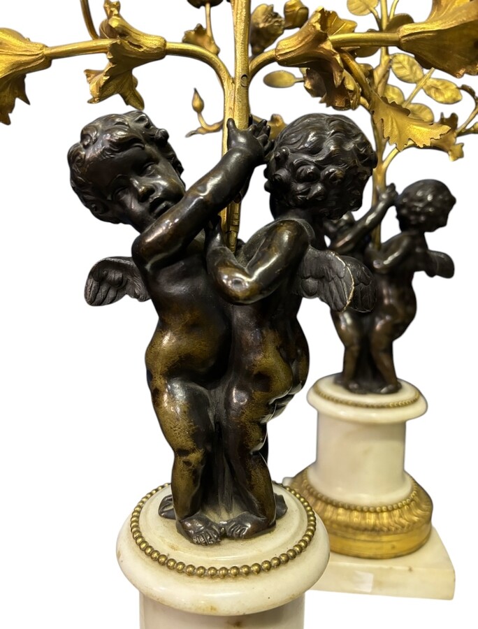 Pair of Napoleon III ‘2 angels’ bronze candelabras. Nice 19thC. candelabra representing a pair of angels carrying 3 gilt bronze candelabra with sprigs of flowers resting on a white marble base.