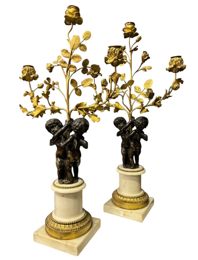 Pair of Napoleon III ‘2 angels’ bronze candelabras. Nice 19thC. candelabra representing a pair of angels carrying 3 gilt bronze candelabra with sprigs of flowers resting on a white marble base.