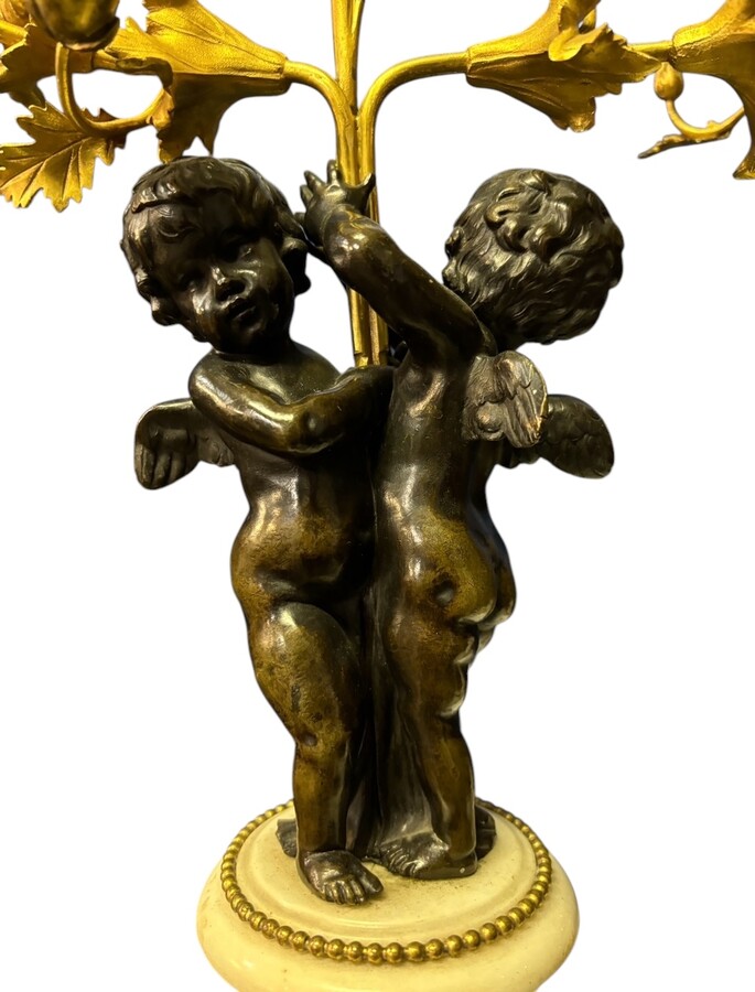 Pair of Napoleon III ‘2 angels’ bronze candelabras. Nice 19thC. candelabra representing a pair of angels carrying 3 gilt bronze candelabra with sprigs of flowers resting on a white marble base.