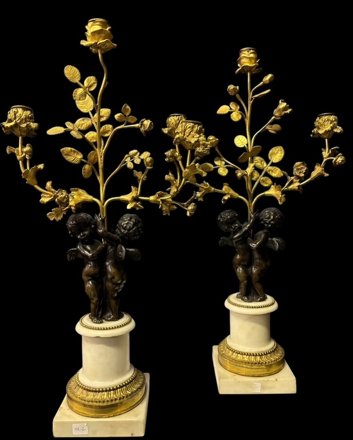 Pair of Napoleon III ‘2 angels’ bronze candelabras. Nice 19thC. candelabra representing a pair of angels carrying 3 gilt bronze candelabra with sprigs of flowers resting on a white marble base.