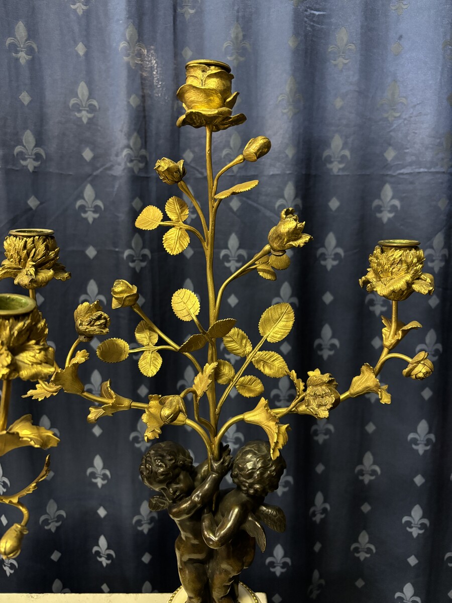 Pair of Napoleon III ‘2 angels’ bronze candelabras. Nice 19thC. candelabra representing a pair of angels carrying 3 gilt bronze candelabra with sprigs of flowers resting on a white marble base.