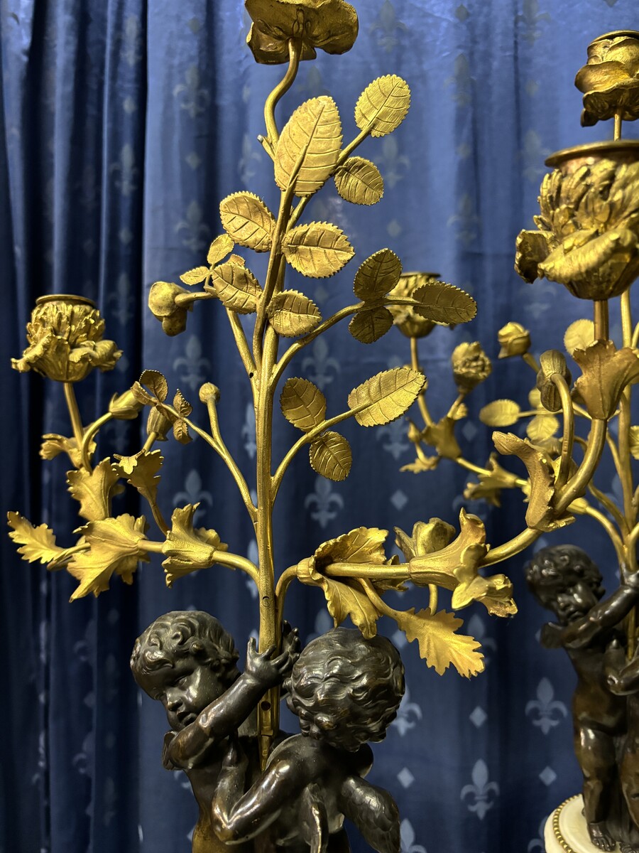 Pair of Napoleon III ‘2 angels’ bronze candelabras. Nice 19thC. candelabra representing a pair of angels carrying 3 gilt bronze candelabra with sprigs of flowers resting on a white marble base.