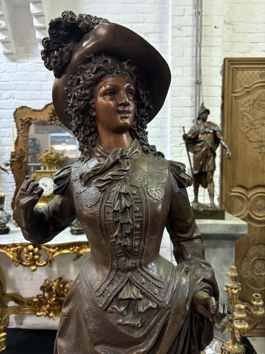 Very large bronze sculpture ‘noble lady ’ 19th century ( 103 cm ). Elegant sculpture of a noble lady with feather hat, signed by Ernest Rancoulet ( French 1870-1915 ). In good condition, with a dent in the base. 