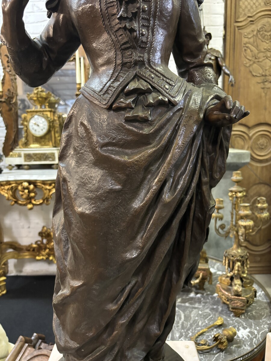 Very large bronze sculpture ‘noble lady ’ 19th century ( 103 cm ). Elegant sculpture of a noble lady with feather hat, signed by Ernest Rancoulet ( French 1870-1915 ). In good condition, with a dent in the base. 